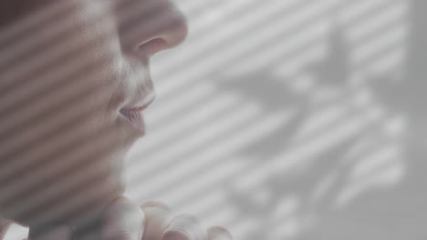 close-up of thoughtful person with shadows of leaves animation over face