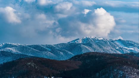 Zeitraffer-Im-Winterberg,-Sich-Schnell-Bewegende,-Flauschige-Wolken-Mit-Dem-Skigebiet-Poiana-Brasov-Im-Hintergrund,-Brasov,-Rumänien