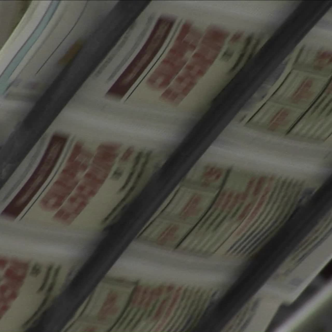 Zeitungen laufen über ein Fließband in einer Zeitungsfabrik 6