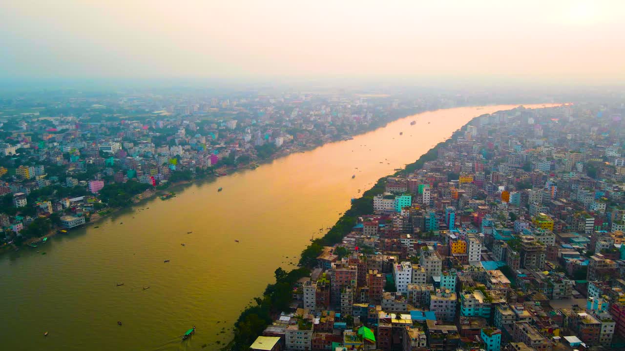 Aerial over Dhaka and the Buriganga River in Bangladesh at sunset on a hazy, overcast day