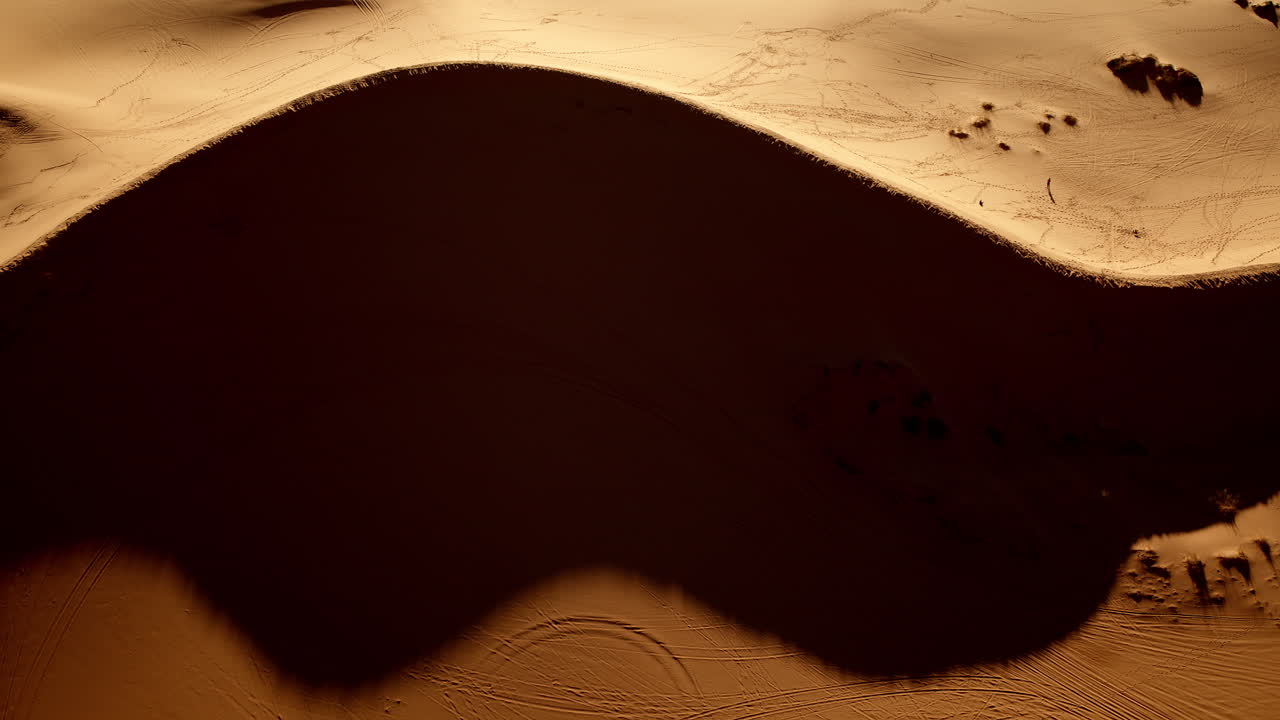 A surreal aerial view captures the stunning colors and shapes of Southern Utah’s pink sand dunes.