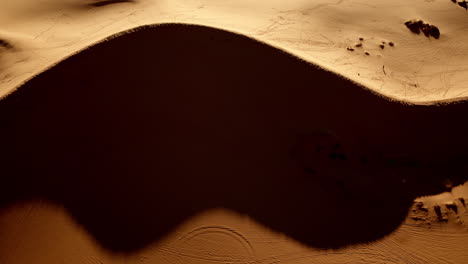 a surreal aerial view captures the stunning colors and shapes of southern utah’s pink sand dunes.