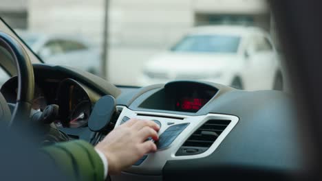 driver pressing buttons on center console inside card