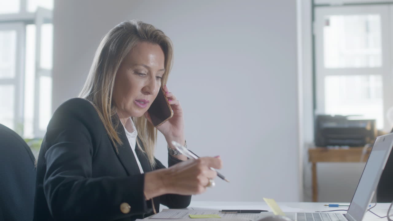 Successful middle-aged woman talking on phone
