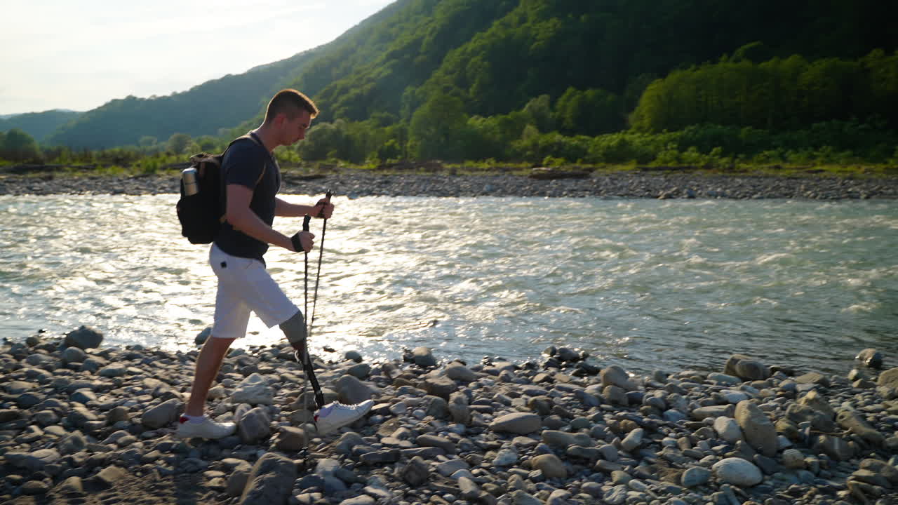 인공 다리를 가진 사람이 강 의 산에서 하이킹을 하고 있다