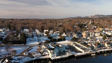 aerial slide to the right over a snow dusted downtown camden maine at sunrise