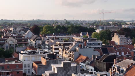 Drone-shot-of-Roeselare-during-golden-hour-at-sunset,-hovering-over-the-city