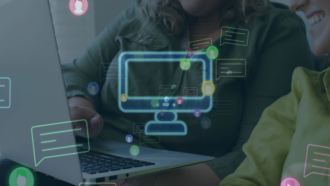 animación de computadoras y iconos de chat sobre dos felices colegas caucásicas que usan una computadora portátil