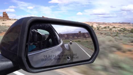 view of a motorcycle in car's mirror in the desert