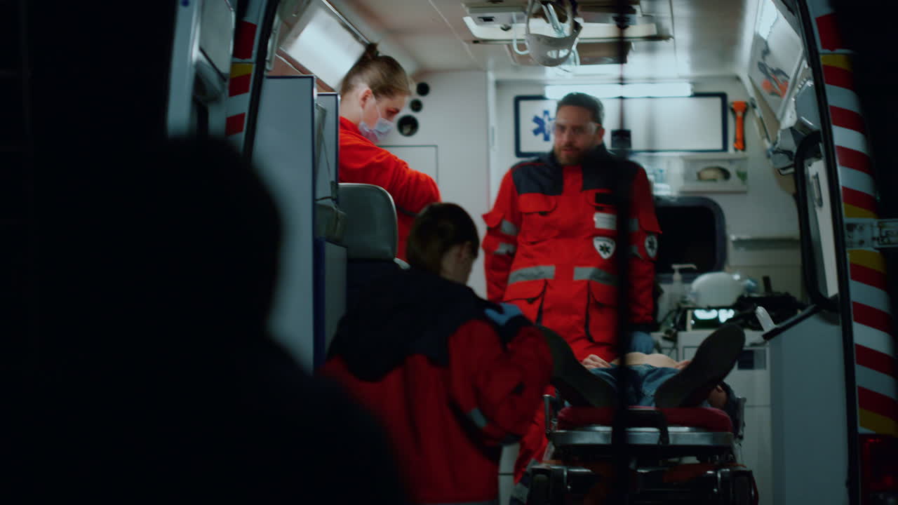 구급대원들이 교통사고 후 환자를 구하고 의사들이 사람을 옮기고 있습니다.