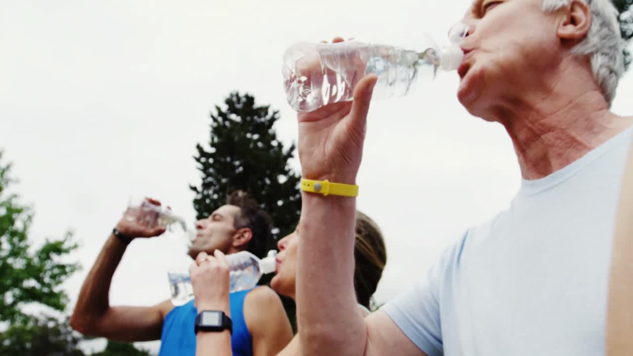 운동 선수 가족이 함께 물을 마시고 있습니다.