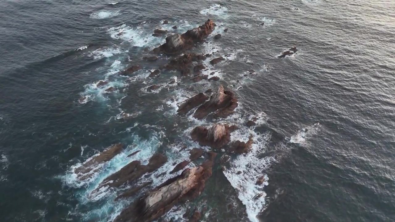 Vista drone su rocce frastagliate e acqua spumeggiante dell'Atlantico sulla costa delle Asturie.