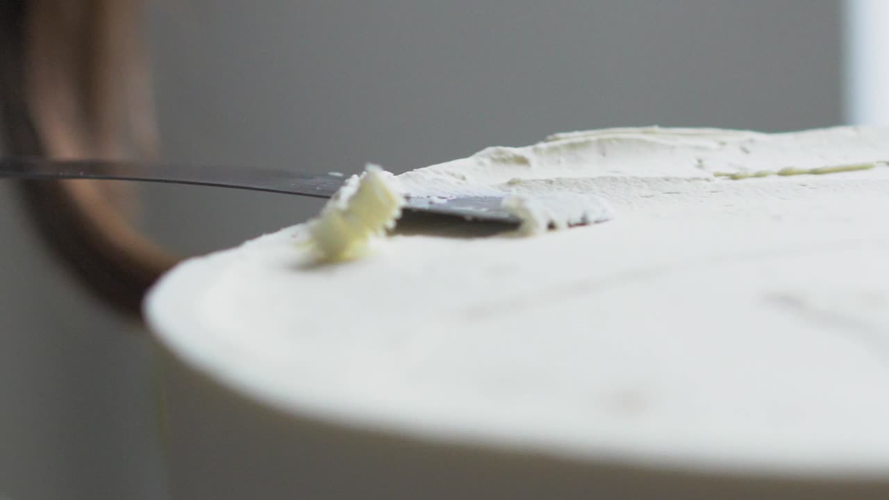 пекарь выравнивает торт ножом медленный момент