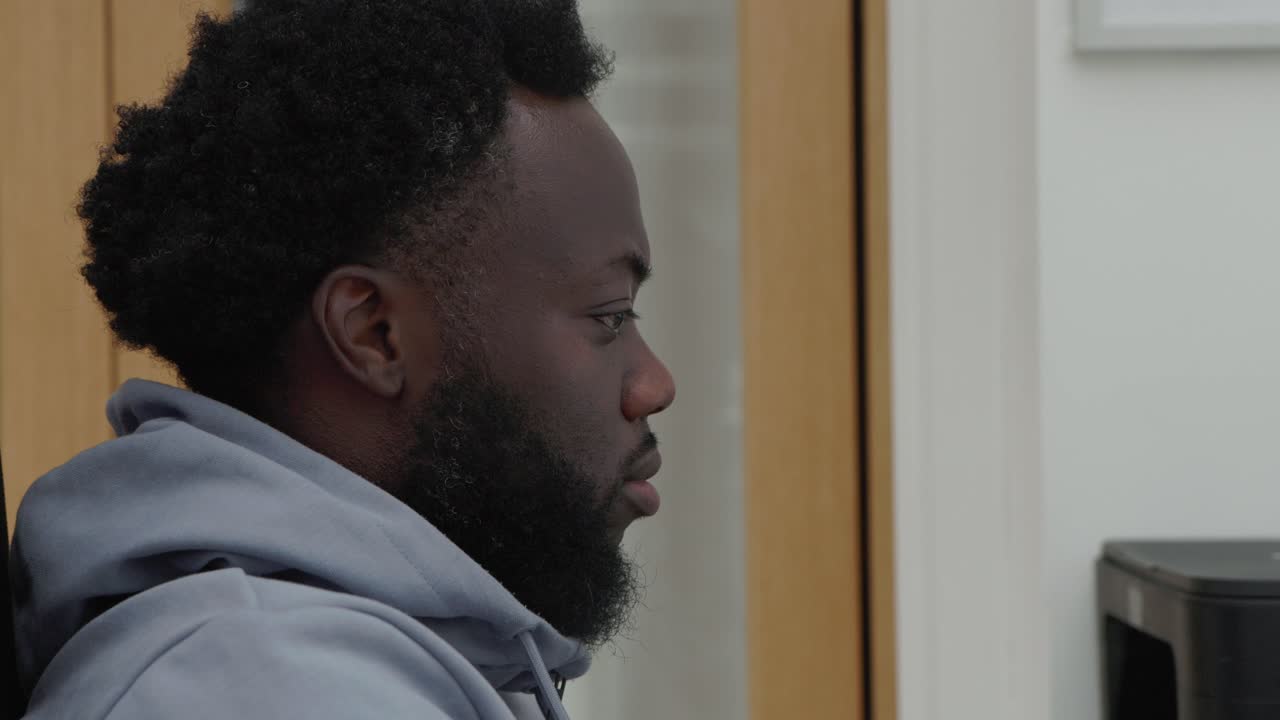 Dolly Pan To Black Male Working At Home Computer Desk