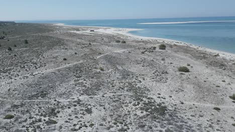 Aerial-view-soaring-over-a-deserted,-blue-water-beach-in-Alentejo,-Portugal