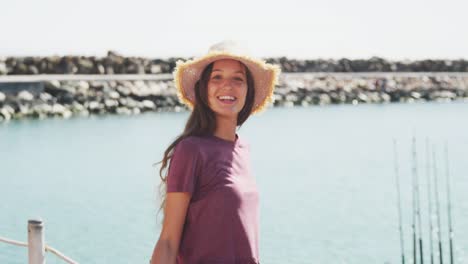 Side-view-of-a-teenage-Caucasian-girl-lokking-at-camera-near-the-sea