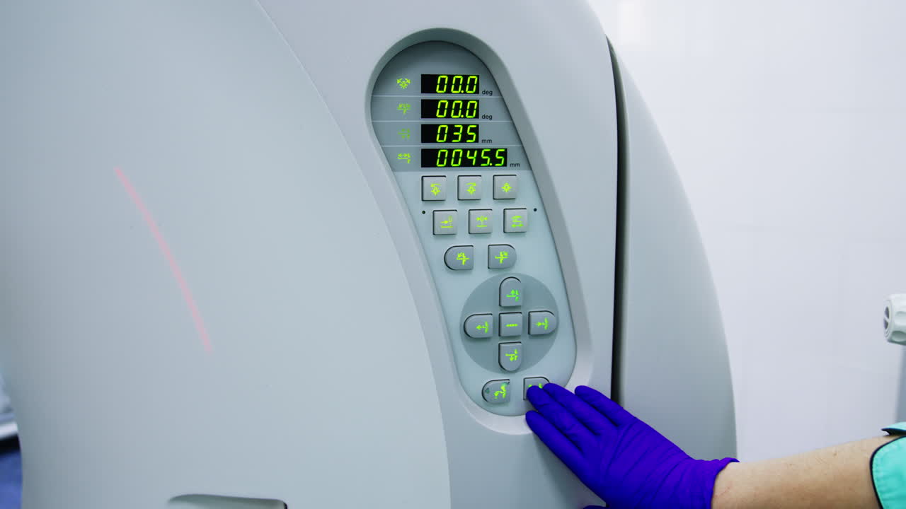 Gloved hand of medic setting the parameters on modern tomography scanner. Patient having a check up at the innovative equipment. Close up.