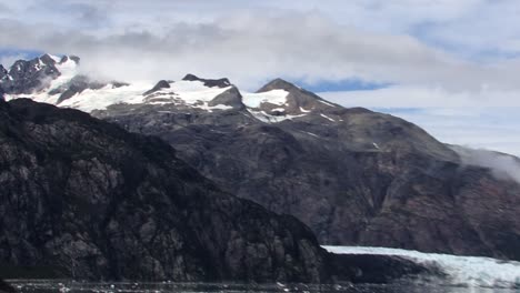 Snow-capped-mountains,-covered-with-clouds-and-Margerie-Glacier-in-Alaska