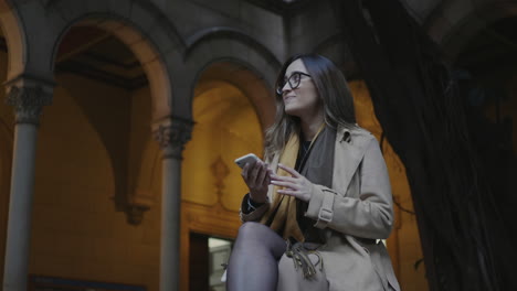 student talking on smartphone at university. woman receiving good news on phone