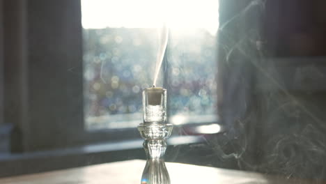 Blowing-Out-A-Candle-With-a-Glass-Window-In-The-Background