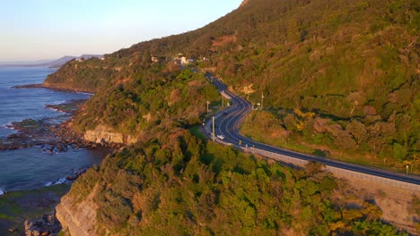 sunrise view of the sea cliff bridge at the edge of new south wales coast in australia - aerial shot