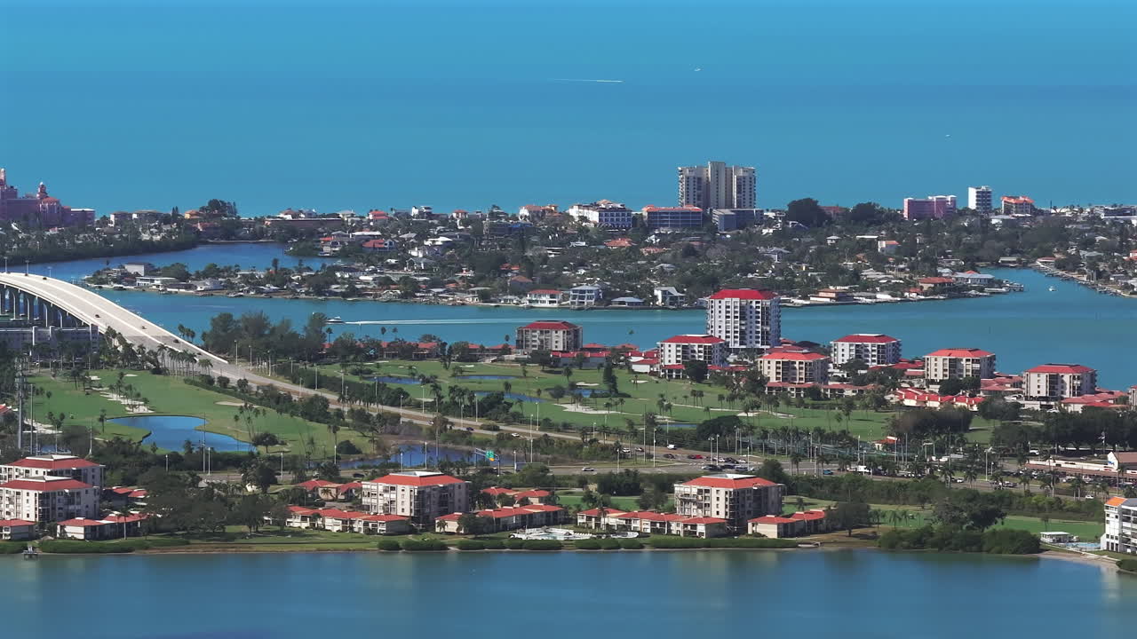 Constant Aerial Panning View of Pass-a-Grille Beach, and iconic Don CeSar Hotel along the connecting waterfront communities, featuring golf courses, condos, in Saint Petersburg, Florida's Gulf Coast