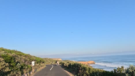 tourists walking along coastal road with ocean view