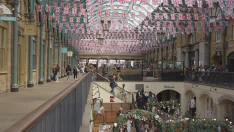 Shops-And-Stalls-In-Covent-Garden-Market-With-Tourists-In-London-UK