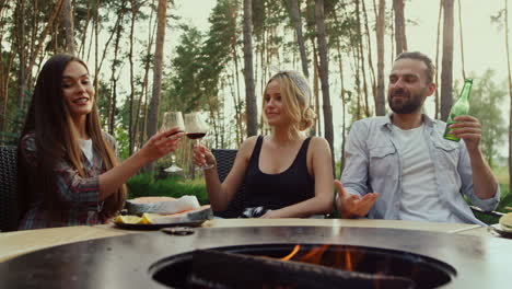 colleagues having informal communication. friends drinking alcohol outdoors