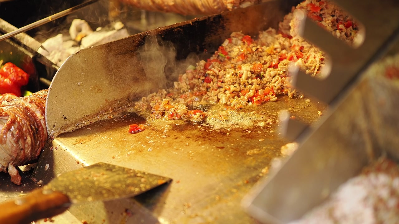Chef Chopping and Grilling Kokoreç with Vegetables on a Hot Plate