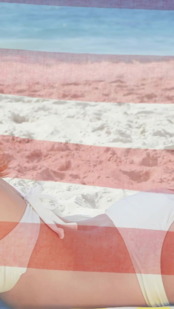 Animation of american flag over caucasian woman relaxing on beach by sea