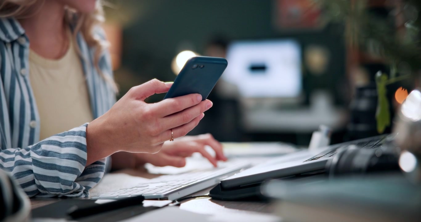 Woman Working on Laptop and Using Smartphone in Office