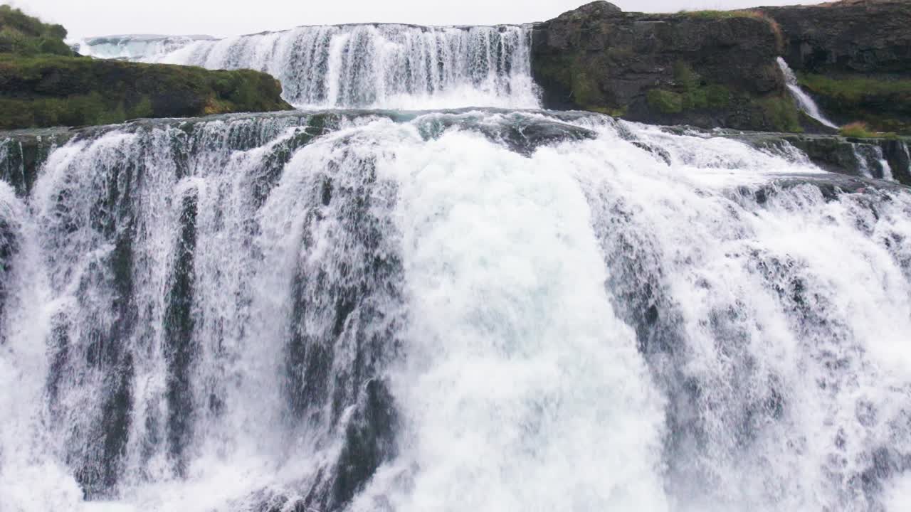 aerial: la cascada de reykjafoss en cámara lenta se presenta como una poderosa cascada de agua