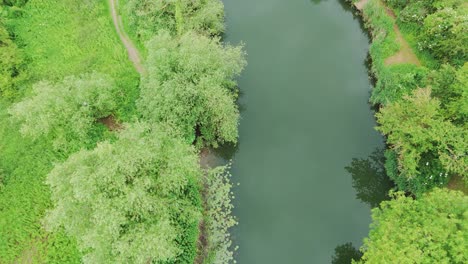 Shot-of-waterway-passing-through-Priory-Park-in-Huntingdonshire,-UK-during-daytime