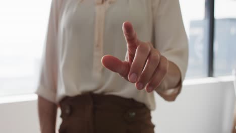 la mano de una mujer de negocios caucásica apuntando algo delante de ella