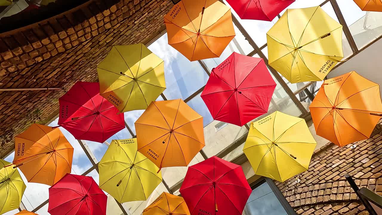 paraguas vibrantes colgando en el mercado de camden, londres