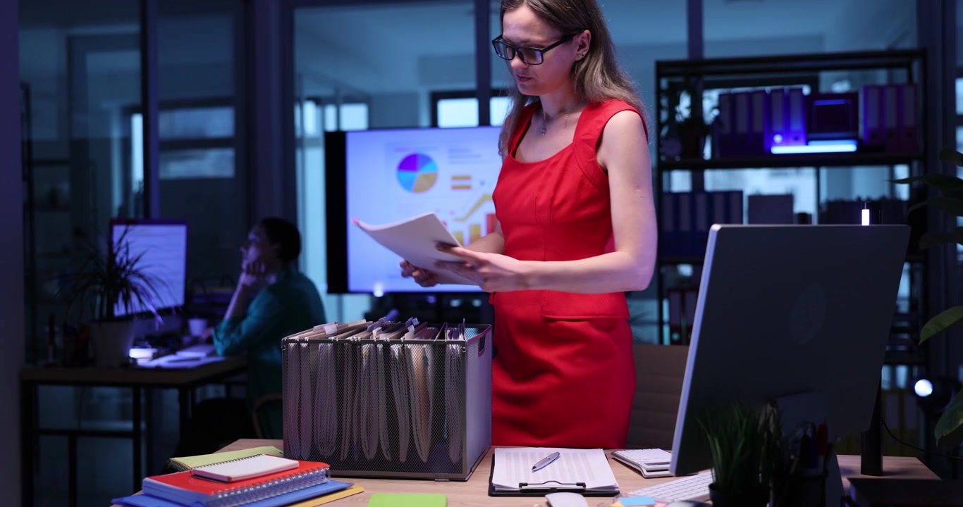 Nervous woman manager seeks files on rack in semidark office