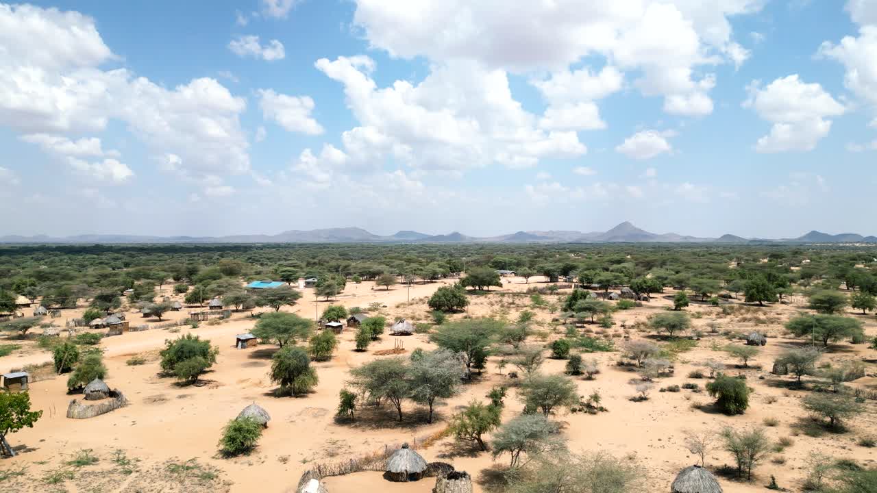 A Drone shot of a village in Northern Kenya where you can see huts, houses, mountains and the general landscape