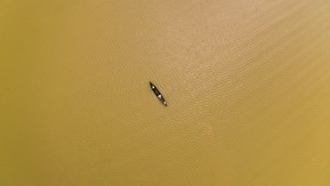 fisherman in his canoe paddling in a lake in west africa