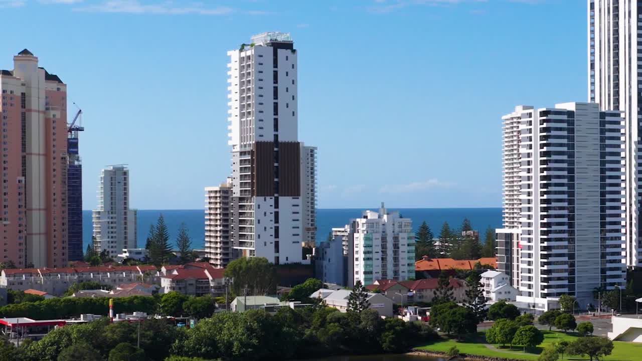 Uma vista de ângulo elevado de edifícios altos contemporâneos com vista para um horizonte de oceano azul.