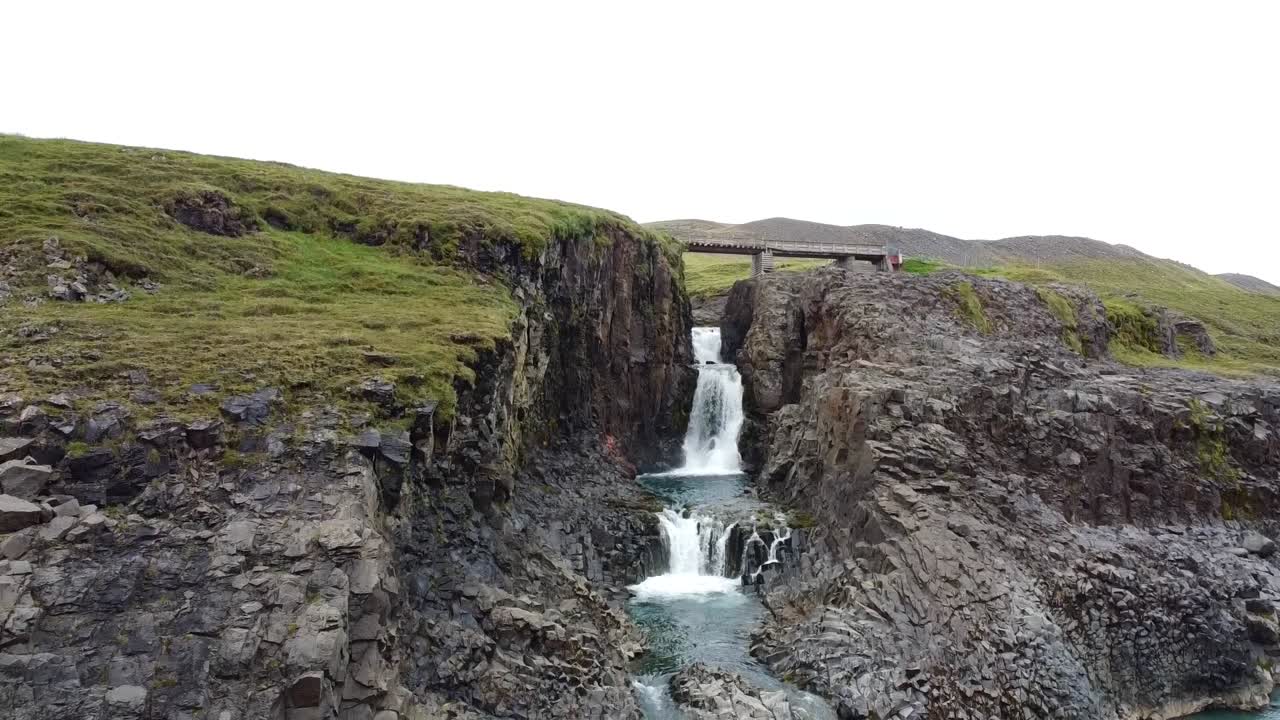 arroyo del río que cae en cascada por el valle rocoso en el agua azul del lago, islandia