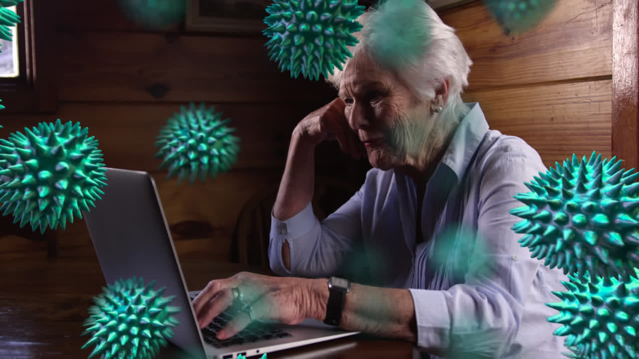 células de covid-19 moviéndose contra una mujer anciana usando una computadora portátil