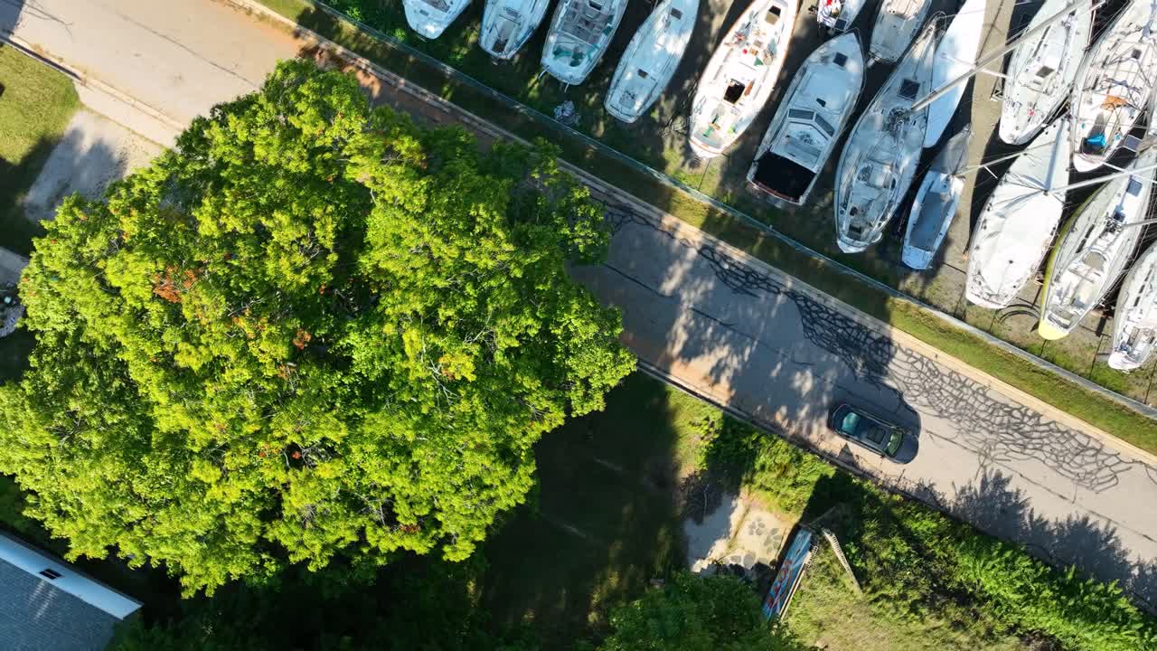 Direct aerial over a boatyard full of sails near a small suburb