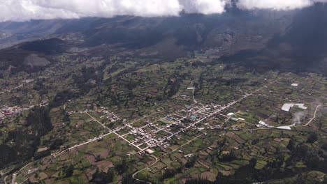 Revealing-drone-shot-of-a-vast-green-valley-and-thick-clouds-next-to-mountains-in-the-highlands-of-the-peruvian-Andes