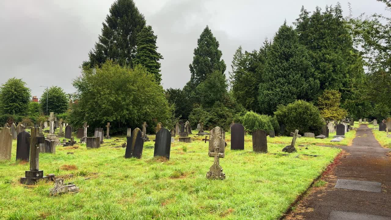Creepy cemetery during the day, abandoned looking tombstone, paved alleyway