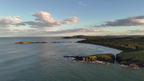 Coastal aerial showing Racecourse Head peninsula stretching into the sea on clear day, Sydney NSW Australia