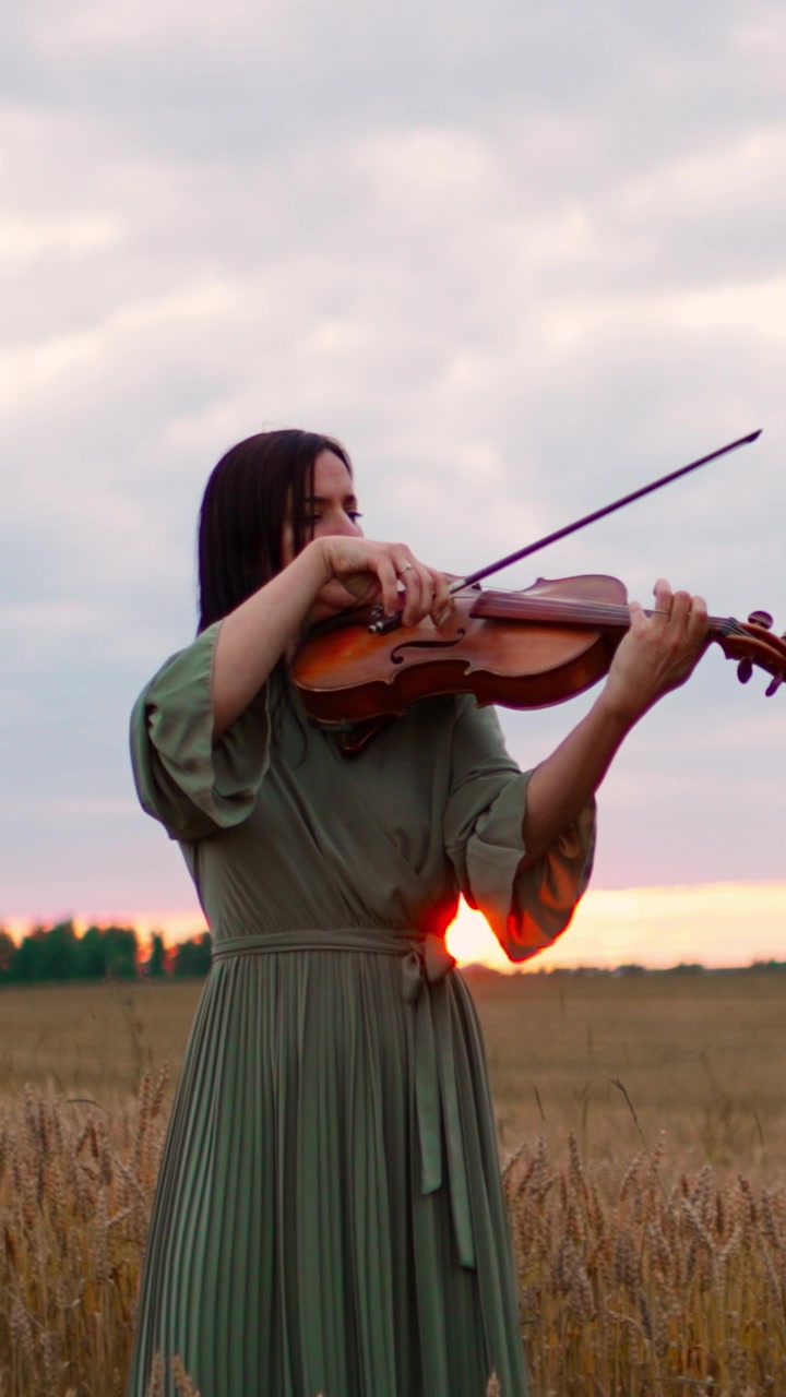 Woman Playing Violin in a Wheat Field at Sunset