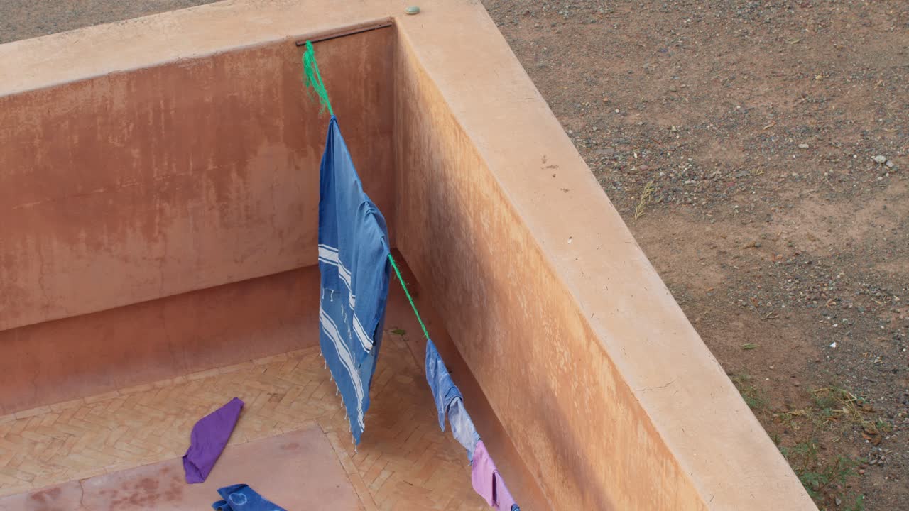 High angle shot of colorful clothes hanging to dry in a geometrical Moroccan courtyard in Marrakech, Morocco, showcasing traditional architecture and daily life