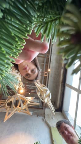 people decorating a christmas wreath and tree