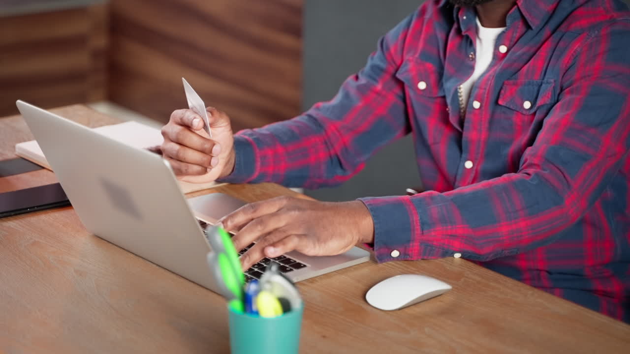 hombre usando portátil y tarjeta de crédito